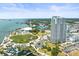 Stunning aerial view highlighting a modern condo with the lush green park, marina, and waterfront views in the background at 331 Cleveland St # 906, Clearwater, FL 33755