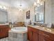 Elegant bathroom featuring a soaking tub, marble countertops, and a decorative chandelier at 331 Cleveland St # 906, Clearwater, FL 33755