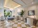 Bright living room featuring a decorative chandelier, modern furnishings, and views of swaying palm trees at 331 Cleveland St # 906, Clearwater, FL 33755