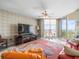 This living room features a decorative ceiling fan, water views, and a modern entertainment center at 331 Cleveland St # 906, Clearwater, FL 33755