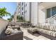 Outdoor patio features wicker furniture, a dining table, and views of tropical landscaping at 331 Cleveland St # 906, Clearwater, FL 33755