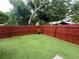 This backyard features artificial turf and a wooden fence with hanging lights at 351 Hancock St, Dunedin, FL 34698