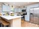 Kitchen featuring white countertops, light blue cabinets, stainless appliances, and hardwood floors at 351 Hancock St, Dunedin, FL 34698