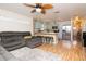 Inviting living space connecting to the kitchen, featuring hardwood floors and a large gray sectional at 351 Hancock St, Dunedin, FL 34698