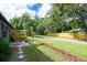 This is a view of the side yard and patio featuring a table and chairs under the canopy at 351 Hancock St, Dunedin, FL 34698