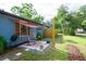 Side yard features a concrete patio, table, chairs, and a canopy for shade at 351 Hancock St, Dunedin, FL 34698