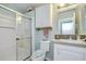 Updated bathroom with glass enclosed shower, white vanity, and convenient storage at 37642 Landis Ave, Zephyrhills, FL 33541