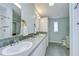 Bathroom featuring double sinks, tiled countertops, and walk-in shower at 37642 Landis Ave, Zephyrhills, FL 33541