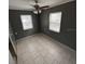 This bedroom features neutral walls, white tile floors and a ceiling fan with light at 37913 Wicklow Ave, Zephyrhills, FL 33541