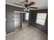 This bedroom features a sliding mirrored closet, neutral walls and white tile floors at 37913 Wicklow Ave, Zephyrhills, FL 33541