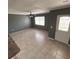 Well-lit living room with tile flooring, ceiling fan, and a bright white front door at 37913 Wicklow Ave, Zephyrhills, FL 33541