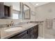 Bathroom with granite countertops, dual sinks, wood cabinetry, and modern fixtures at 4694 Huron Rd, St Petersburg, FL 33708