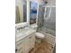 Bathroom with granite vanity, art, blue tile walls, and glass shower doors at 5012 Starfish Se Dr # B, St Petersburg, FL 33705
