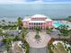 Aerial view of pink condo building featuring a circular driveway, landscaping, and ocean views at 5012 Starfish Se Dr # B, St Petersburg, FL 33705