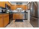 Well-lit kitchen featuring stainless steel appliances, wood cabinets, and a neutral tile floor at 5012 Starfish Se Dr # B, St Petersburg, FL 33705