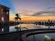 Heated community pool with ocean view at dusk with colorful sunset in the background at 5012 Starfish Se Dr # B, St Petersburg, FL 33705