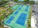 Aerial view of blue and green tennis and pickleball courts with lights and parking at 5012 Starfish Se Dr # B, St Petersburg, FL 33705