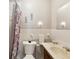 A well-lit bathroom including tile walls, a floral shower curtain, toilet, sink, and decorative wall hangings at 5812 52Nd N Ave, Kenneth City, FL 33709