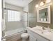 A clean bathroom featuring a shower-tub combo with sliding glass doors and a modern vanity with a large mirror at 5812 52Nd N Ave, Kenneth City, FL 33709