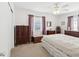 A well-lit bedroom with vintage furnishings including matching chests of drawers, a comfortable bed and large windows at 5812 52Nd N Ave, Kenneth City, FL 33709