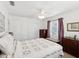 A cozy bedroom with a comfortable bed, a ceiling fan, and ample natural light streaming through the windows at 5812 52Nd N Ave, Kenneth City, FL 33709