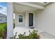 Inviting home entrance with a covered porch and a stylish front door, enhanced by colorful flowers at 6281 Dry Tortugas Dr, Sarasota, FL 34241