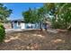 A spacious backyard features a concrete patio and mature tree. A fire pit provides warmth in the yard at 6409 N 23Rd St, Tampa, FL 33610