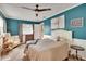 Bright bedroom featuring blue accent walls, neutral carpet, and a ceiling fan at 6409 N 23Rd St, Tampa, FL 33610