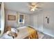 Bright bedroom features a ceiling fan, soft natural light, and a closet with sliding doors at 6409 N 23Rd St, Tampa, FL 33610