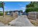 This charming blue house features a fenced in yard, long driveway, and shed at 6409 N 23Rd St, Tampa, FL 33610