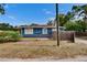 A charming single-story home showcases a blue exterior, well-maintained landscaping, and white trimmed windows at 6409 N 23Rd St, Tampa, FL 33610
