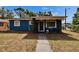 Charming blue home featuring a red front door and well-manicured lawn at 6409 N 23Rd St, Tampa, FL 33610