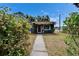 Charming blue one-story home with a red door and inviting front walkway at 6409 N 23Rd St, Tampa, FL 33610