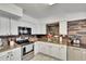 Kitchen featuring stainless steel appliances, granite countertops, and white cabinets at 6409 N 23Rd St, Tampa, FL 33610