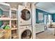 Laundry area features stacked washer and dryer, shelving, and access to bedroom at 6409 N 23Rd St, Tampa, FL 33610