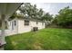 A lush backyard featuring green grass, mature trees, and privacy fence at 6504 N 13Th St, Tampa, FL 33604