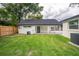 Spacious backyard featuring mature trees, lush grass, and updated exterior at 6504 N 13Th St, Tampa, FL 33604