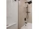 Bathroom featuring black hardware, white tub and shower with tile surround at 6504 N 13Th St, Tampa, FL 33604