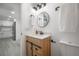 Bathroom featuring a round mirror, light wood vanity and white shower curtain at 6504 N 13Th St, Tampa, FL 33604