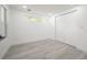 An empty bedroom with a window and double door closet with light gray wood-style flooring at 6504 N 13Th St, Tampa, FL 33604