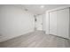 An empty bedroom with a window and double door closet with light gray wood-style flooring at 6504 N 13Th St, Tampa, FL 33604