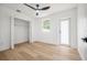 Bedroom with closet, exterior door, ceiling fan and wood floors at 6504 N 13Th St, Tampa, FL 33604