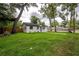 Landscaped home featuring a manicured lawn and mature trees at 6504 N 13Th St, Tampa, FL 33604