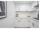Bright kitchen with white cabinets, modern hardware, quartz counters and stainless steel sink at 6504 N 13Th St, Tampa, FL 33604
