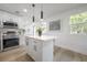 Open concept kitchen with stainless steel appliances, a center island, and modern lighting fixtures at 6504 N 13Th St, Tampa, FL 33604