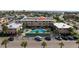 Aerial view of condominium complex featuring a pool, parking, and well-maintained landscaping at 6700 Sunset Way # 303, St Pete Beach, FL 33706
