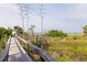 Picturesque beach access featuring a weathered wooden walkway and lush greenery at 6700 Sunset Way # 303, St Pete Beach, FL 33706