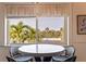Bright dining area with views of the lush palm trees and blue skies from the large window at 6700 Sunset Way # 303, St Pete Beach, FL 33706