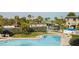 Community pool with beach views offers a relaxing space with lounge chairs and lush landscaping at 6700 Sunset Way # 303, St Pete Beach, FL 33706