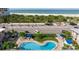 Inviting community pool and lounging area with lush landscaping, steps to the beach at 6700 Sunset Way # 303, St Pete Beach, FL 33706